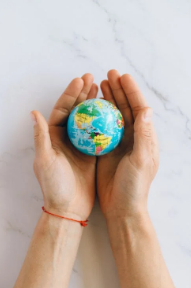 A hand holding a Globe representing Recyclability And Environment 